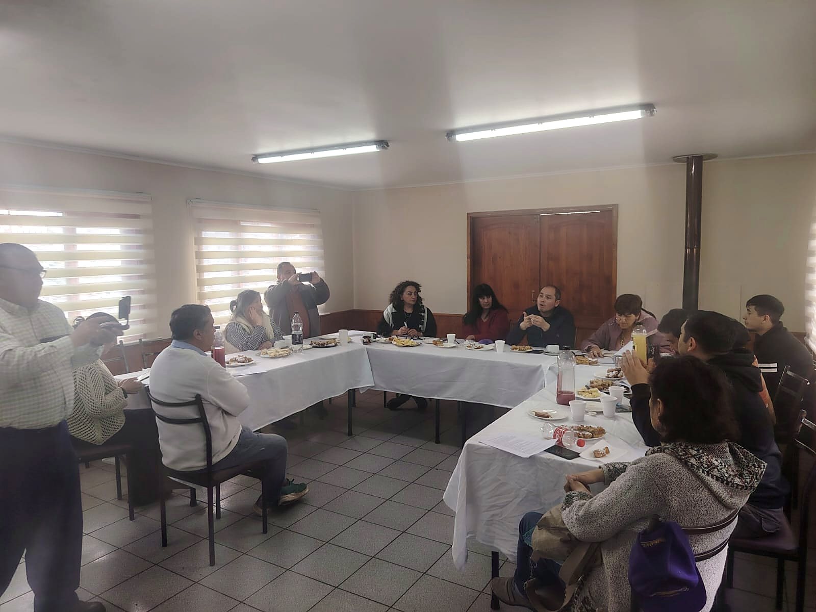 Reunión de la Corporación para el Desarrollo de Río Bueno con los Consejeros Regionales de la Provincia del Ranco, en torno a mesas dispuestas en U.